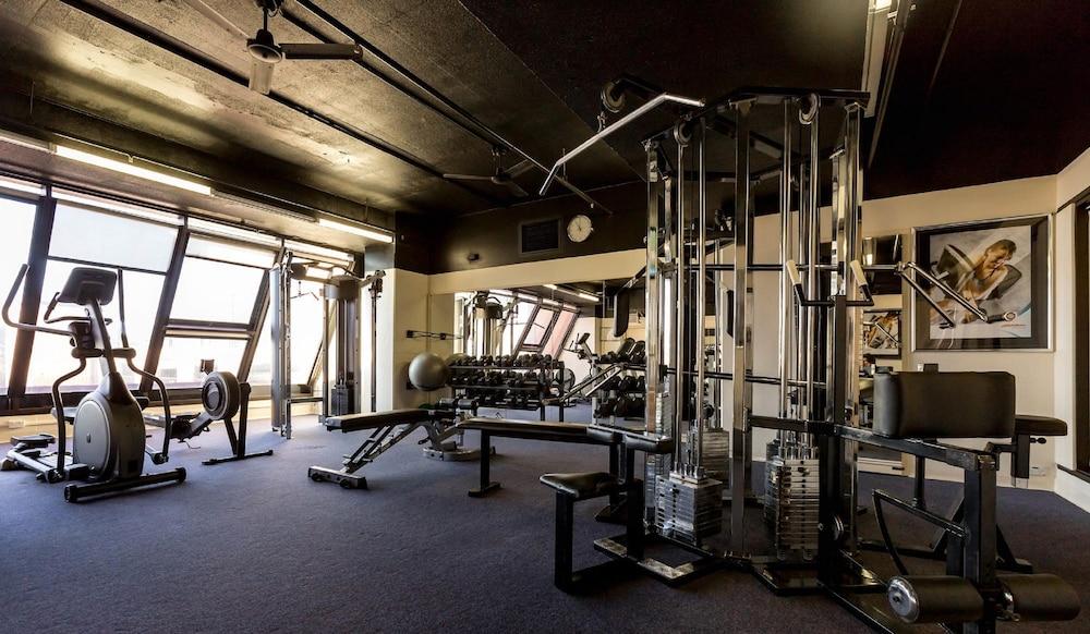 Hotel Stamford Grand Adelaide Glenelg Exterior foto The photo shows the interior of a gym or fitness room. It includes various exercise equipment, such as a multi-station weight machine and rowing machine. The space is well-lit with large windows allowing natural light in, and the walls are decorated 