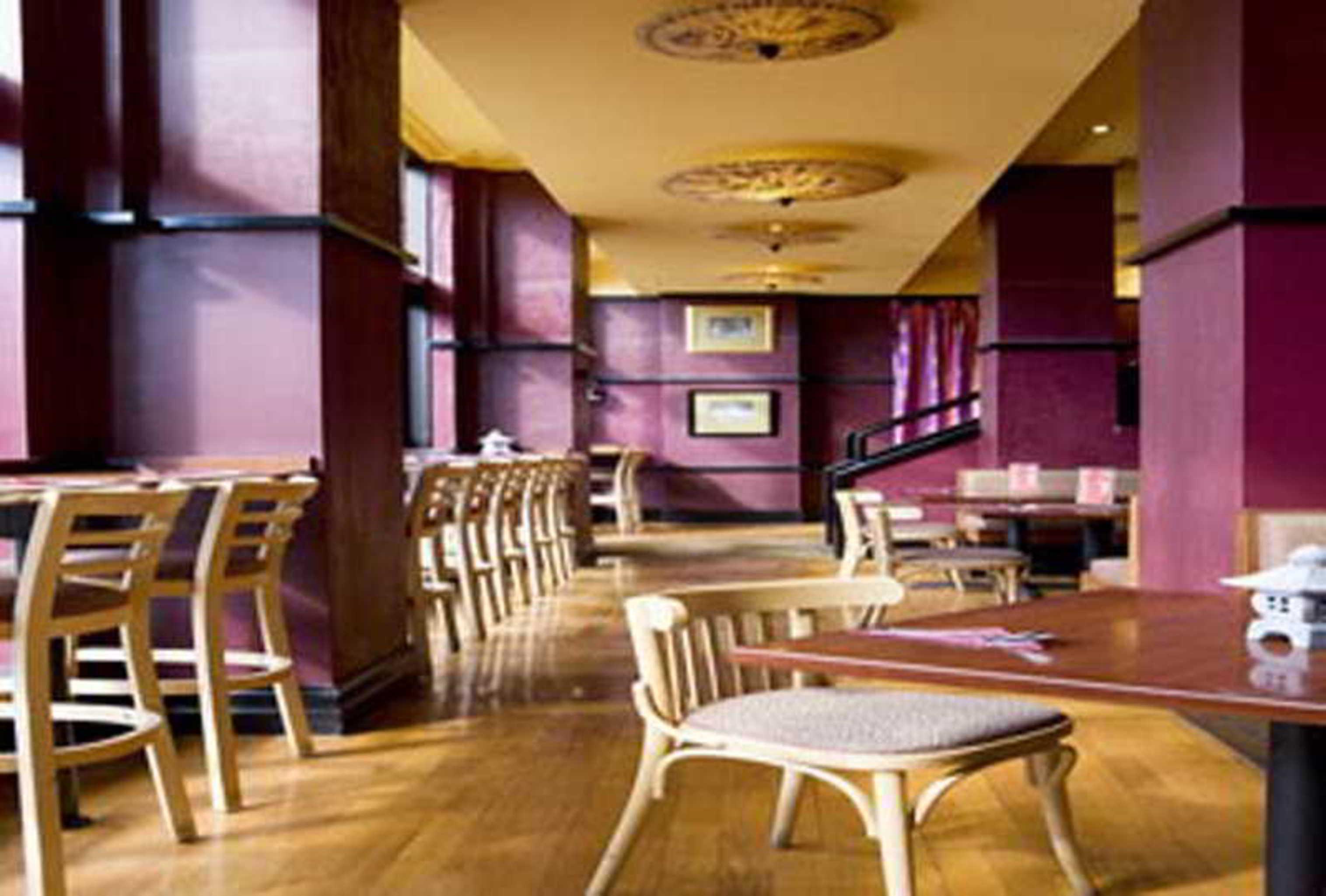 Hotel Stamford Grand Adelaide Glenelg Exterior foto The photo shows the interior of a restaurant. It features wooden flooring and a warm color palette, primarily using shades of burgundy and gold. There are several wooden chairs arranged around tables, with the seating area appearing spacious and invi